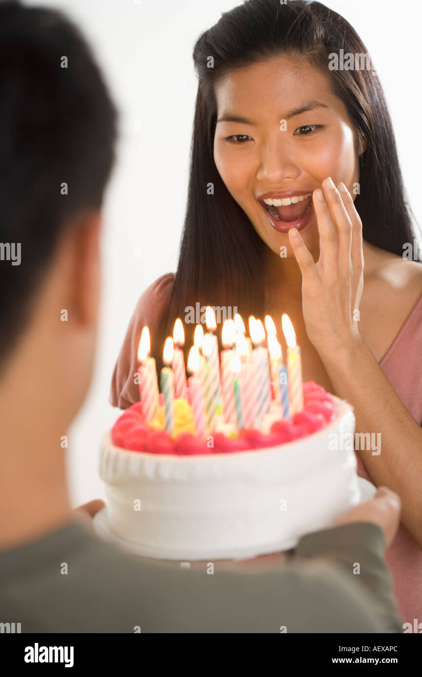 Woman presented with surprise birthday cake Stock Photo