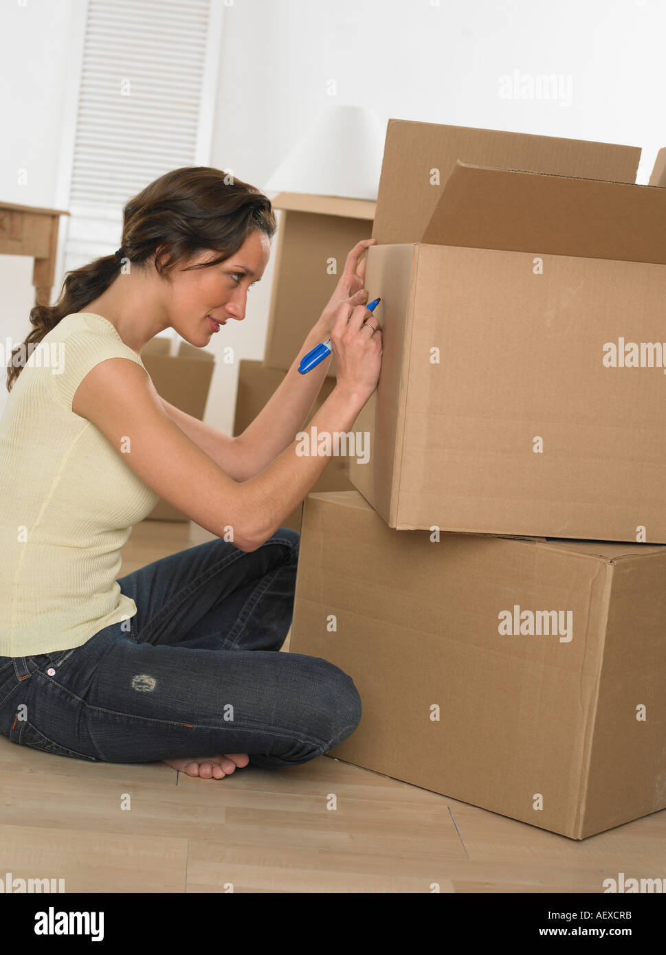 Woman marking boxes on moving day Stock Photo