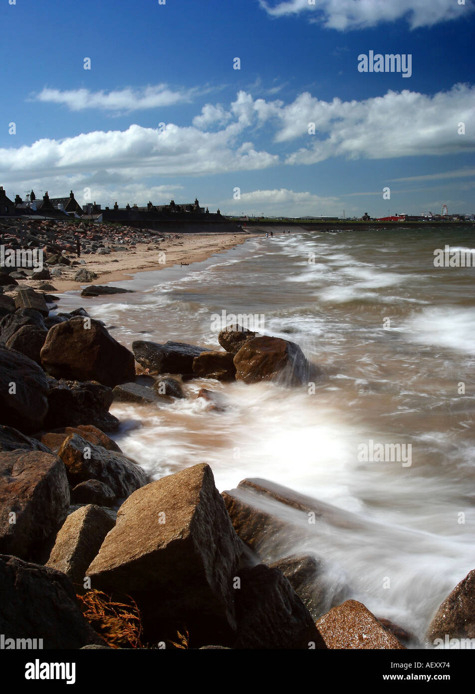 Portrait format image of Aberdeen Beach and promenade Scotland against a blue sky and rocky foreground Stock Photo
