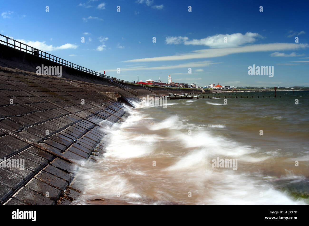 Landscape format image of Aberdeen Beach and promenade Scotland against a blue sky and crashing waves in foreground Stock Photo