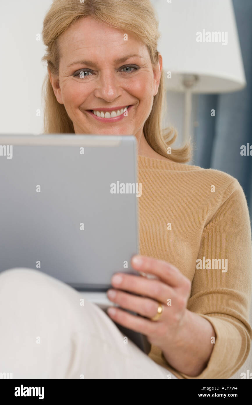 Senior woman using laptop on sofa Stock Photo
