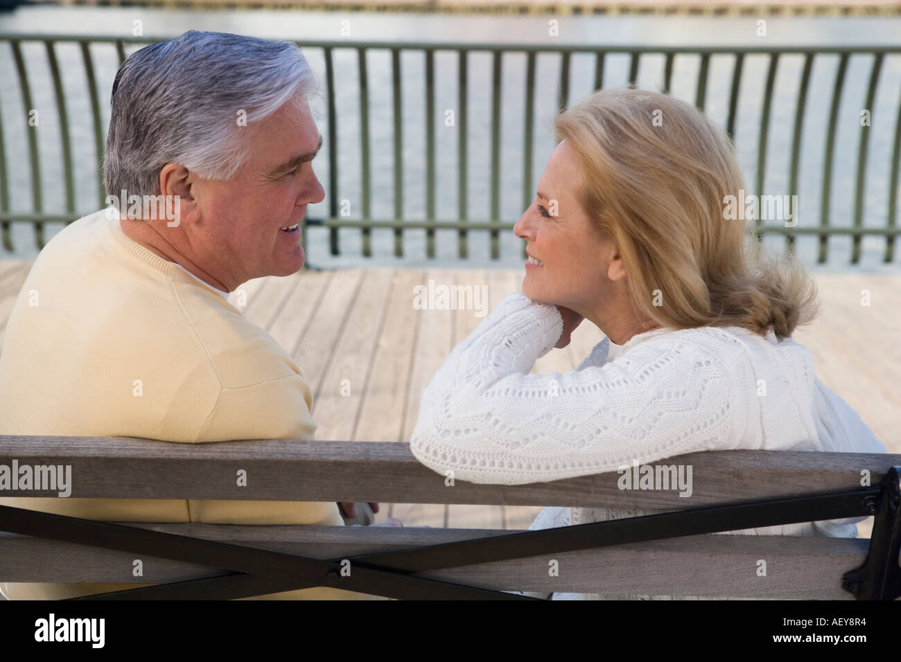 Senior couple sitting on bench outdoors Stock Photo