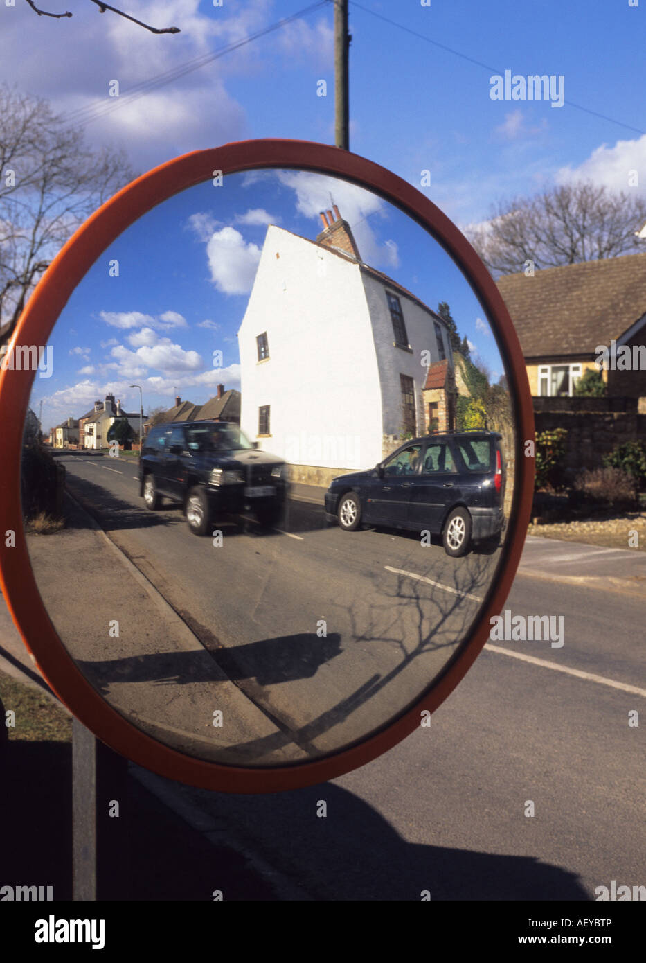 road safety wide angle mirror to assist drivers coming out of driveway onto  main road through village uk Stock Photo - Alamy