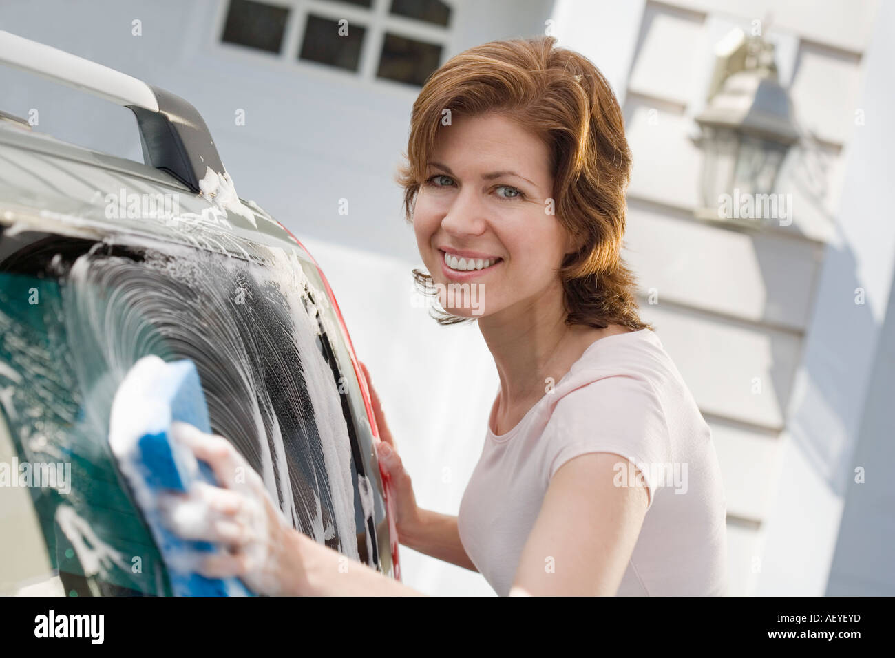 Woman washing car in driveway Stock Photo Alamy