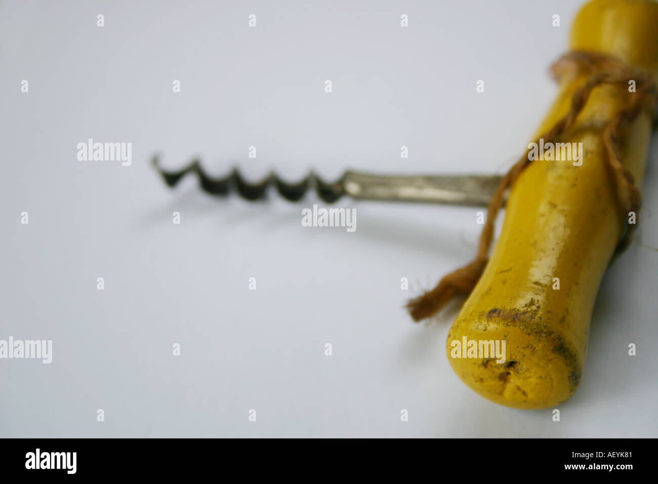 Old fashioned corkscrew with yellow handle and string for opening