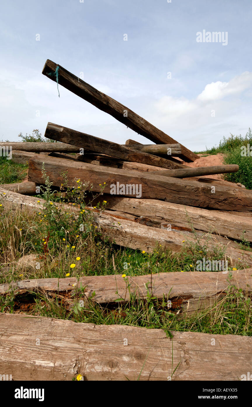 Pile of old telegraph poles and railway sleepers on waste ground Stock Photo