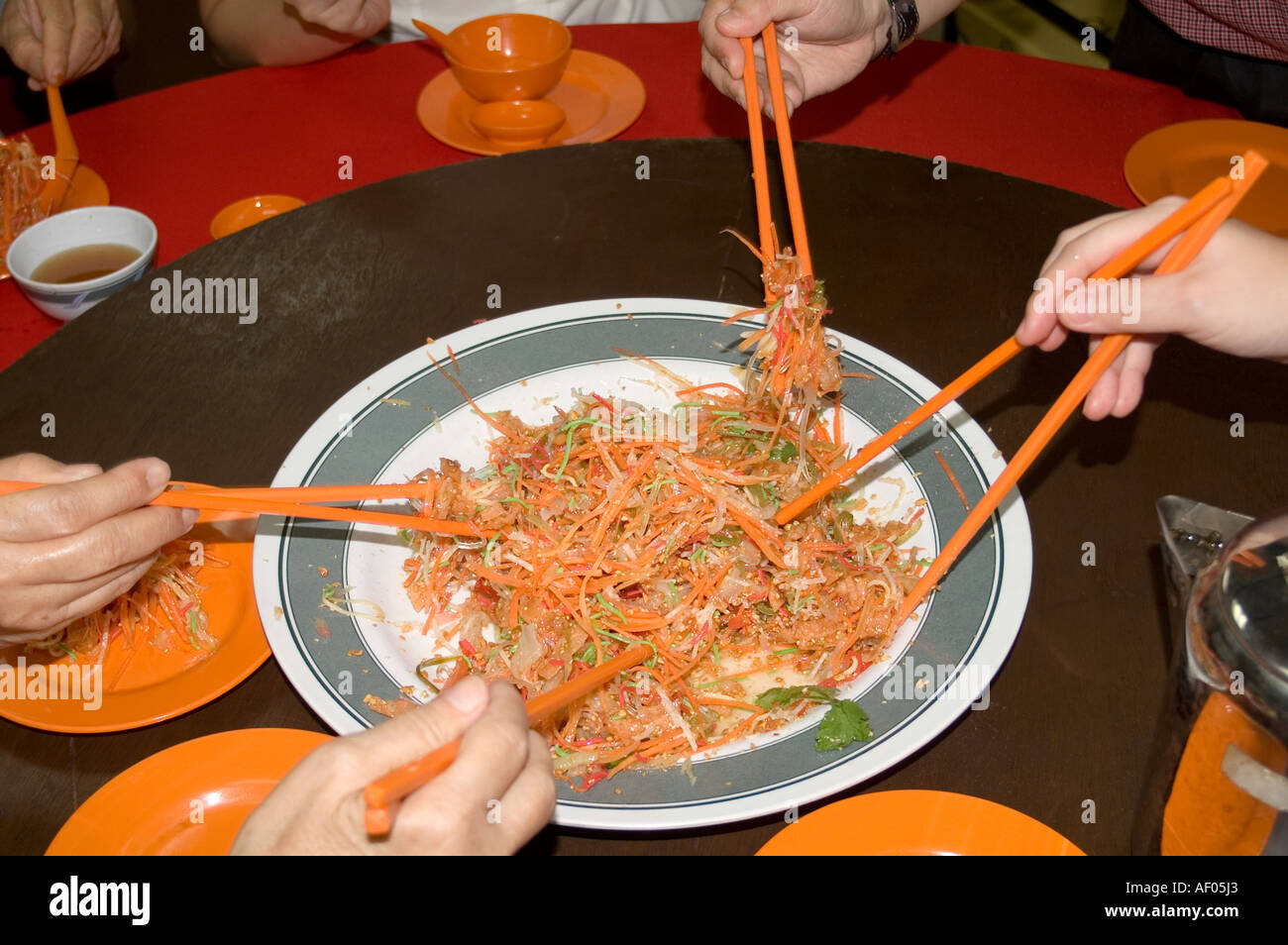 Eating Yee Sang during Chinese New Year Stock Photo