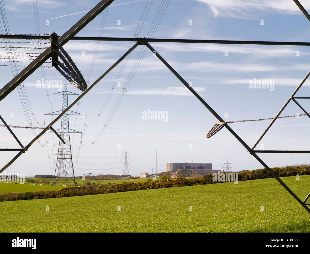 Power lines from Wylfa A Nuclear Power Station seen through metal struts of an electricity pylon Cemaes Anglesey North Wales UK Stock Photo