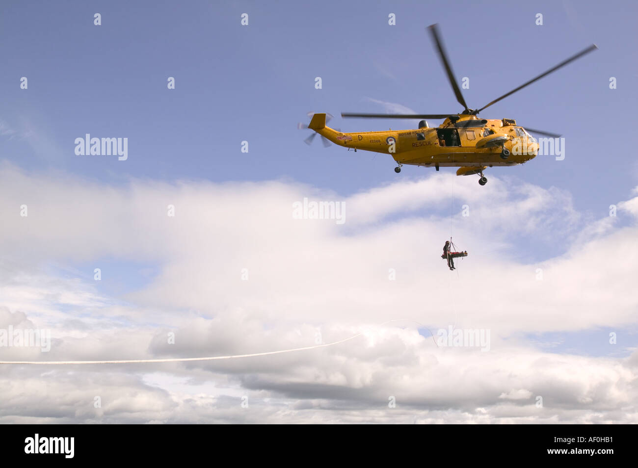 an RAF sea king helicopter whinch up an injured climber with a ...