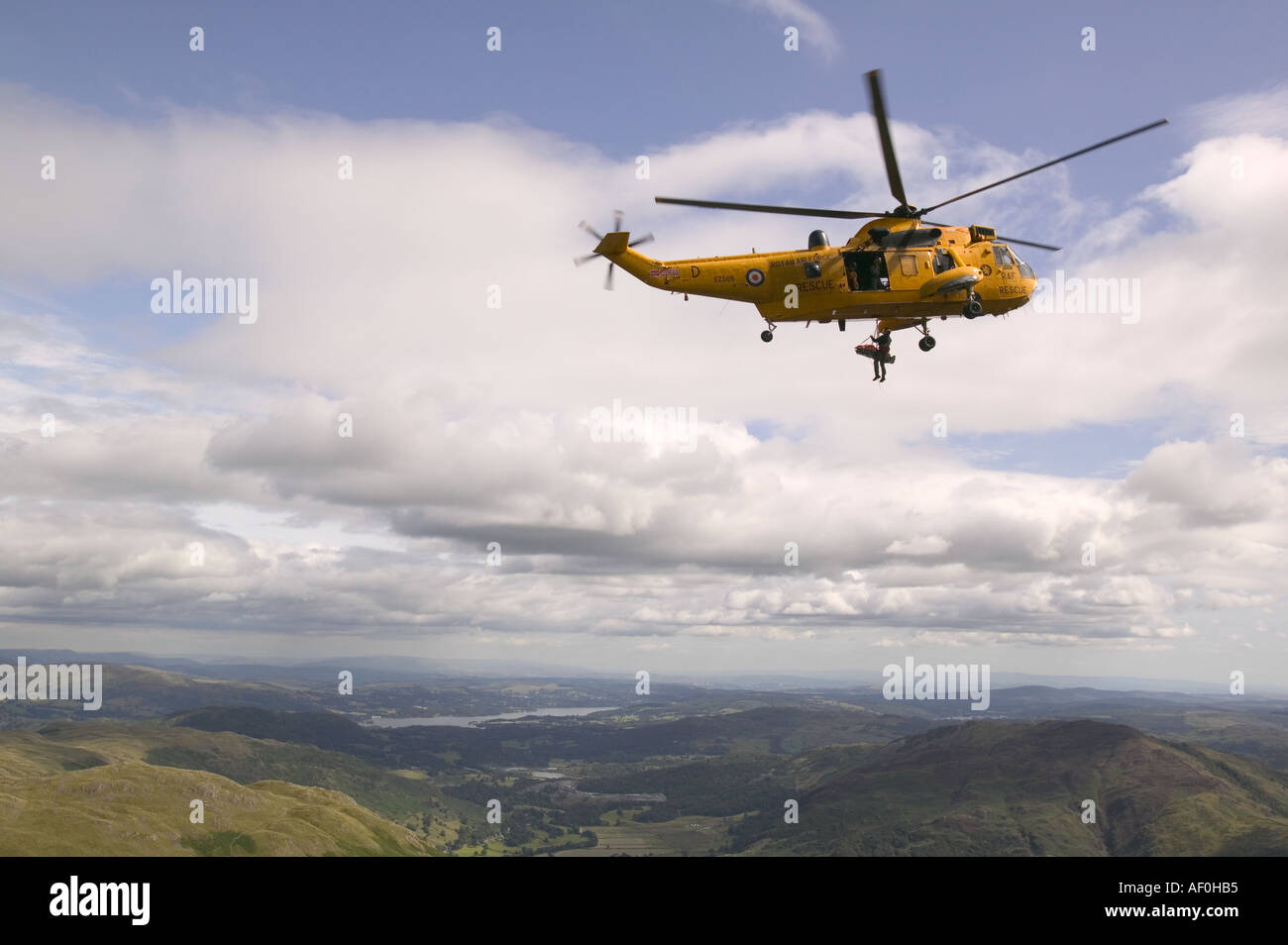an RAF sea king helicopter whinch up an injured climber with a ...