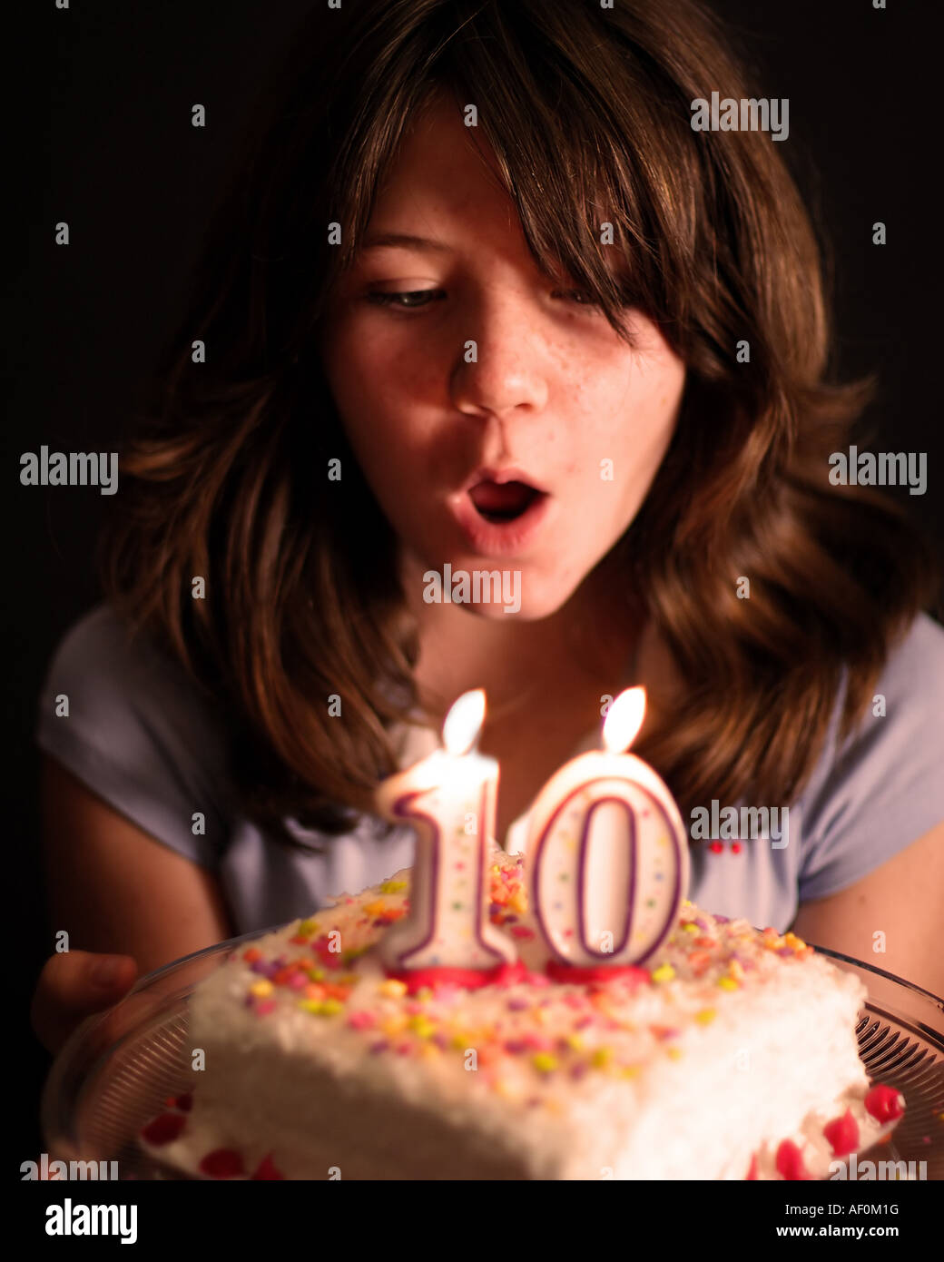 10 year old girl blows out birthday candles Stock Photo Alamy