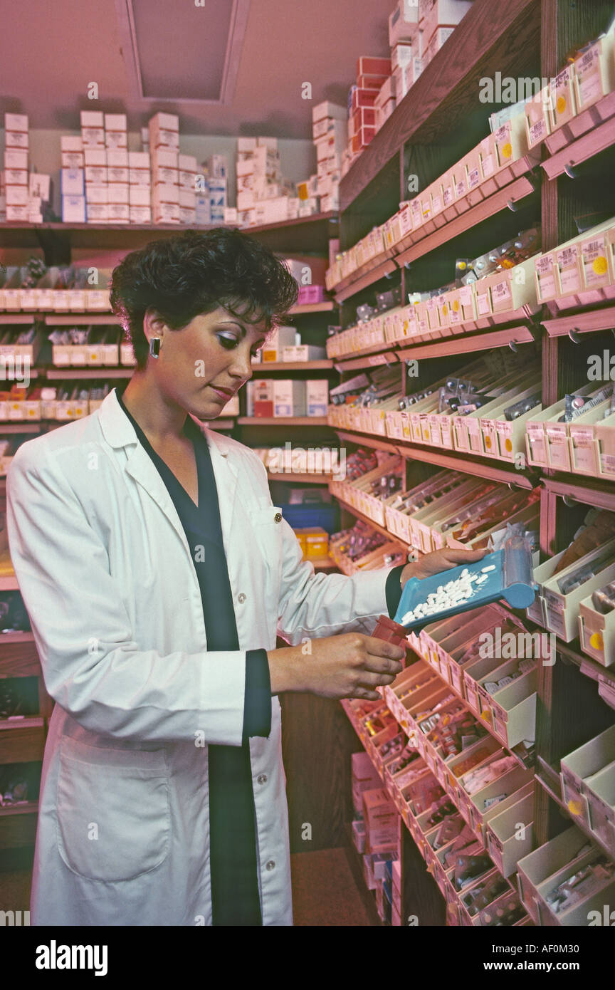 female pharmacist dispensing pills in pharmacy Stock Photo Alamy