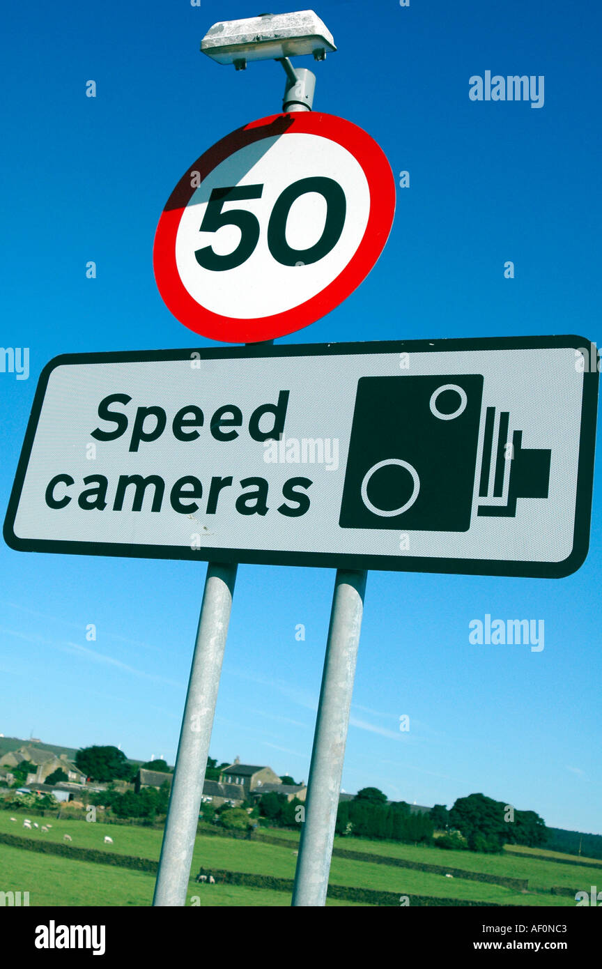Speed limit road sign warning of speed cameras with fields in background Stock Photo
