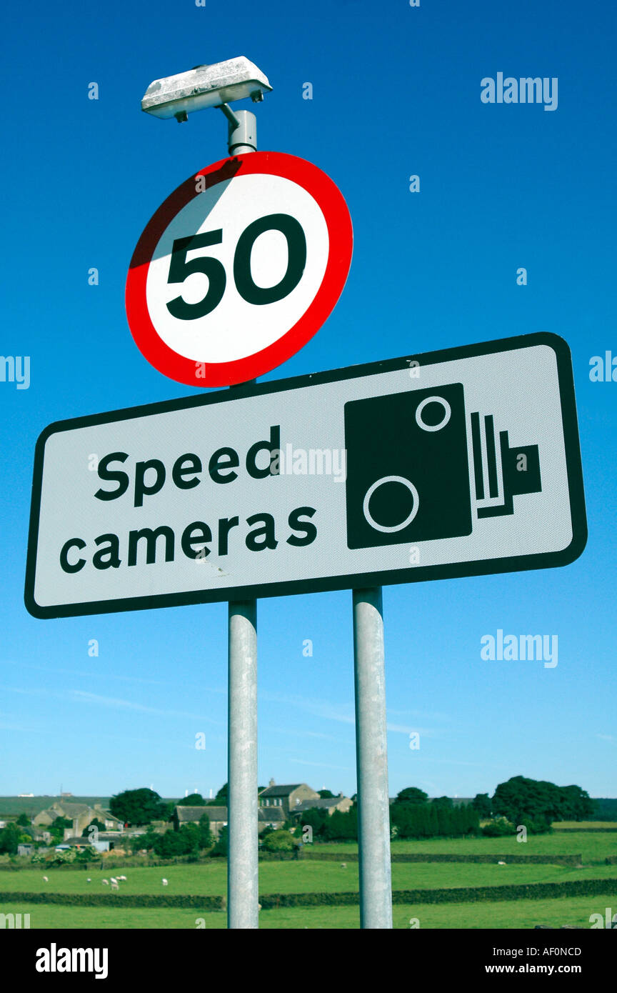 Speed limit road sign warning of speed cameras with fields in background Stock Photo