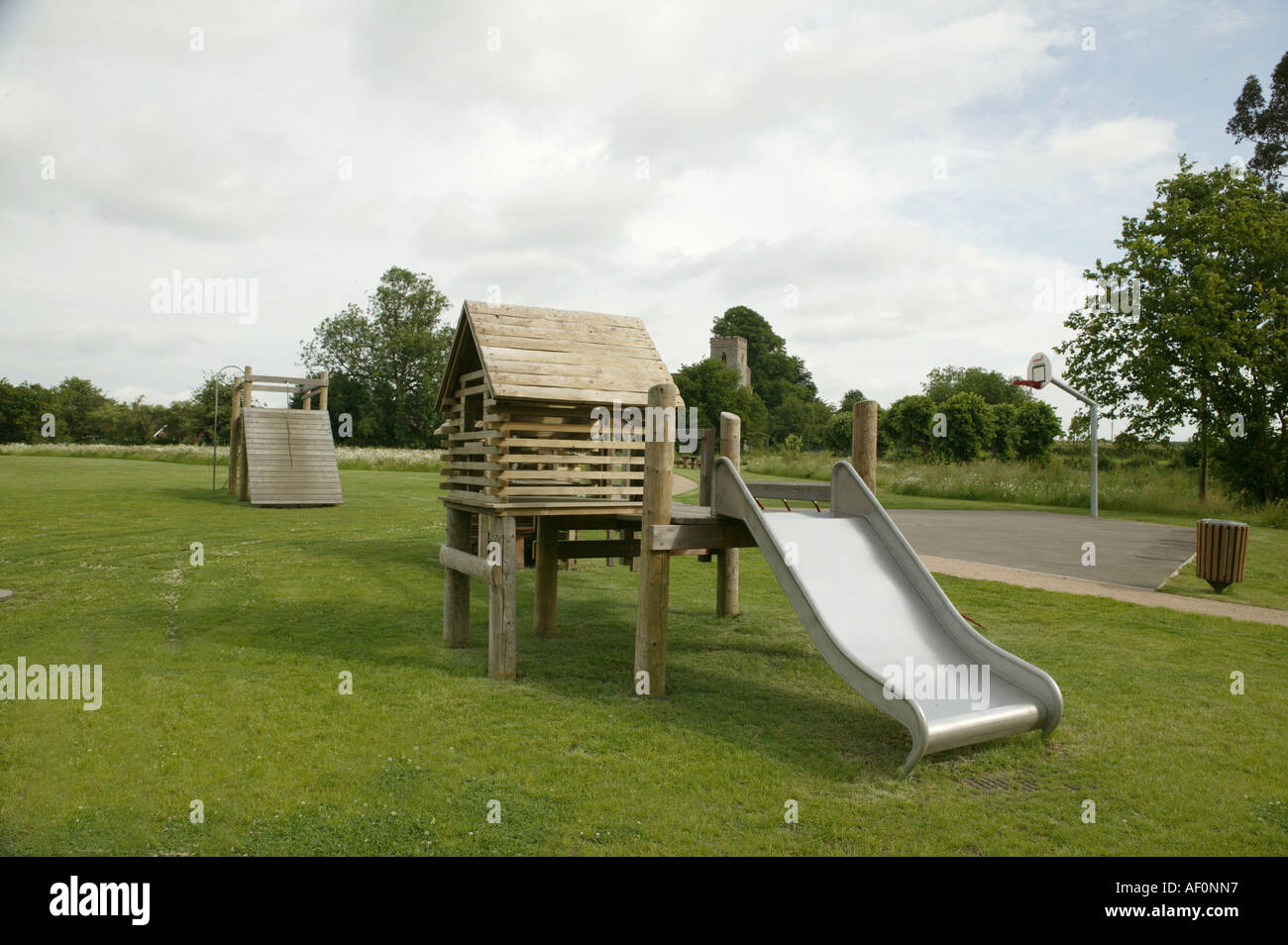 silver slide in a childs play area popular with friends and Mothers Swings Slides and climbing apperatus Stock Photo