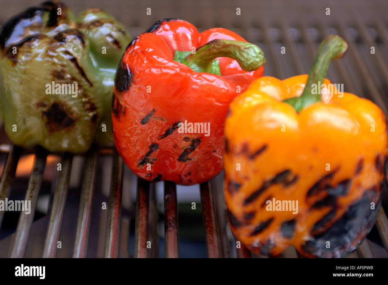 Grill marks from the hot grids are visible on three different bell peppers Stock Photo