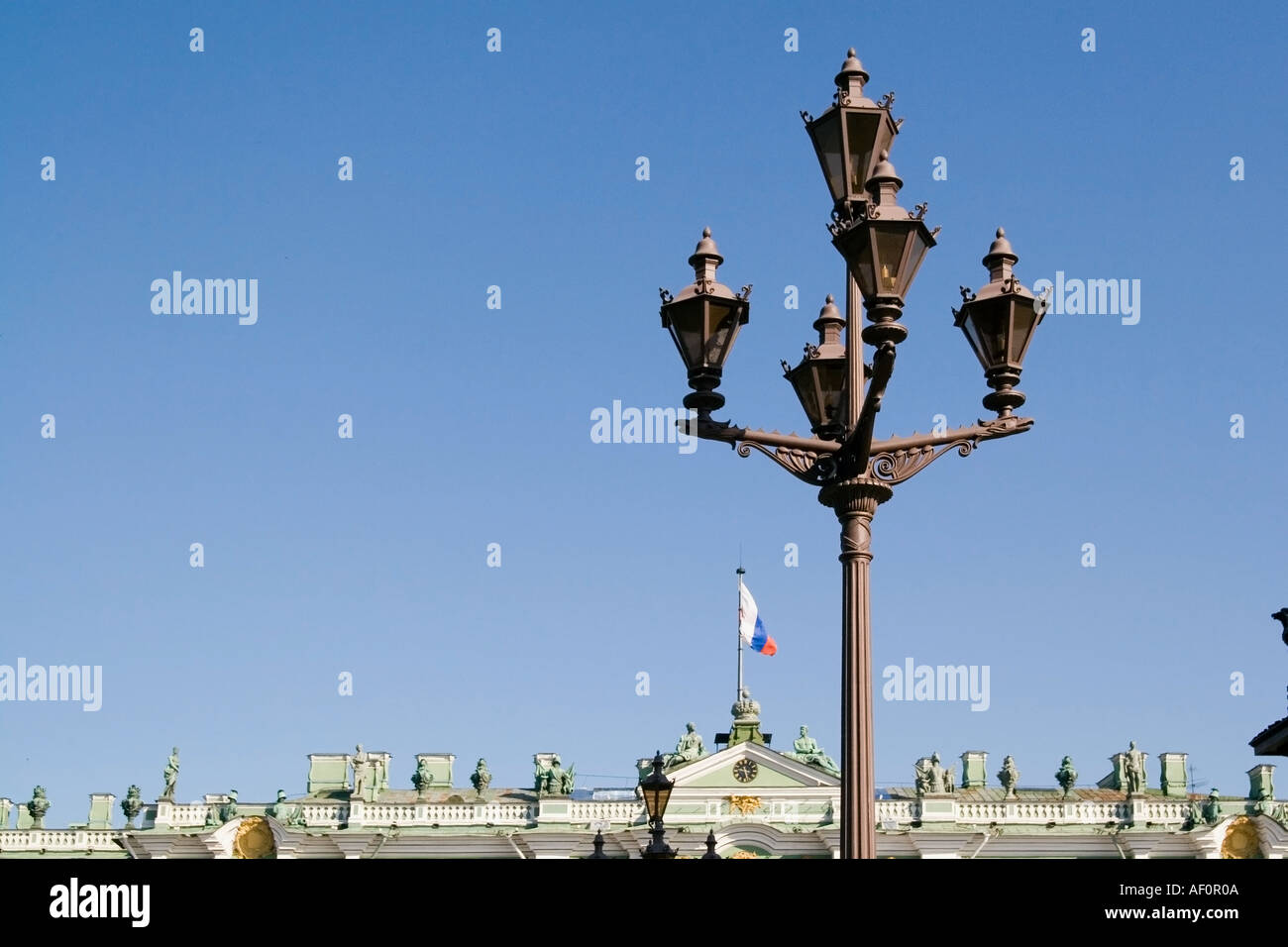 Ornate lanterns opposite the Hermitage Palace and square the Winter Palace St Petersburg Russia Russian flag in distance Stock Photo