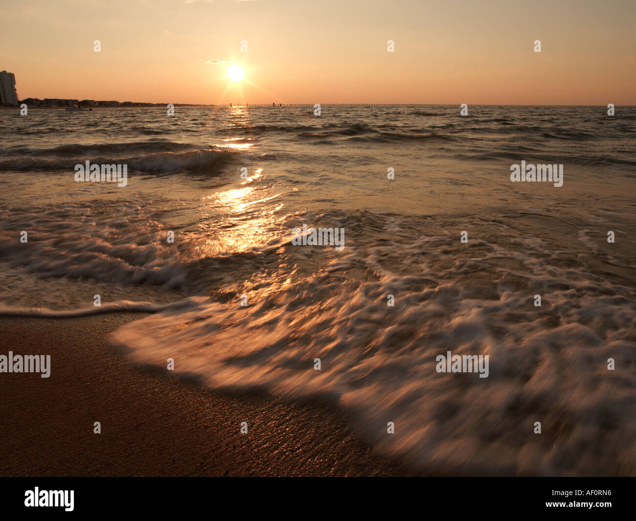 Sunset over Chesapeake Bay Bridge Tunnel with beach in foreground
