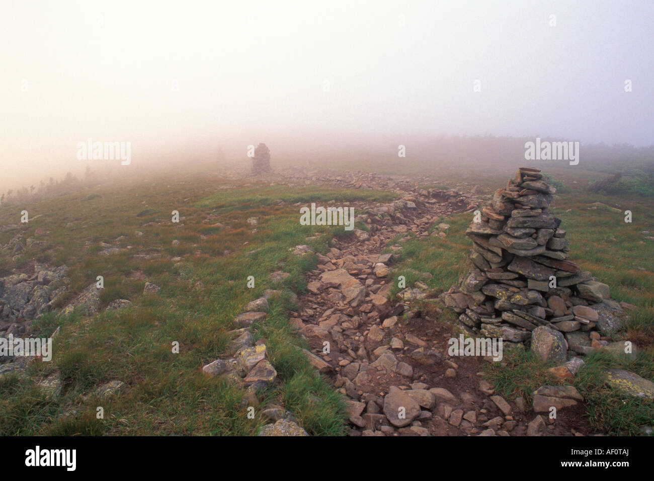 Trail and stone cairns in fog on mount moosilauke peak white mountains new hampshire Stock Photo