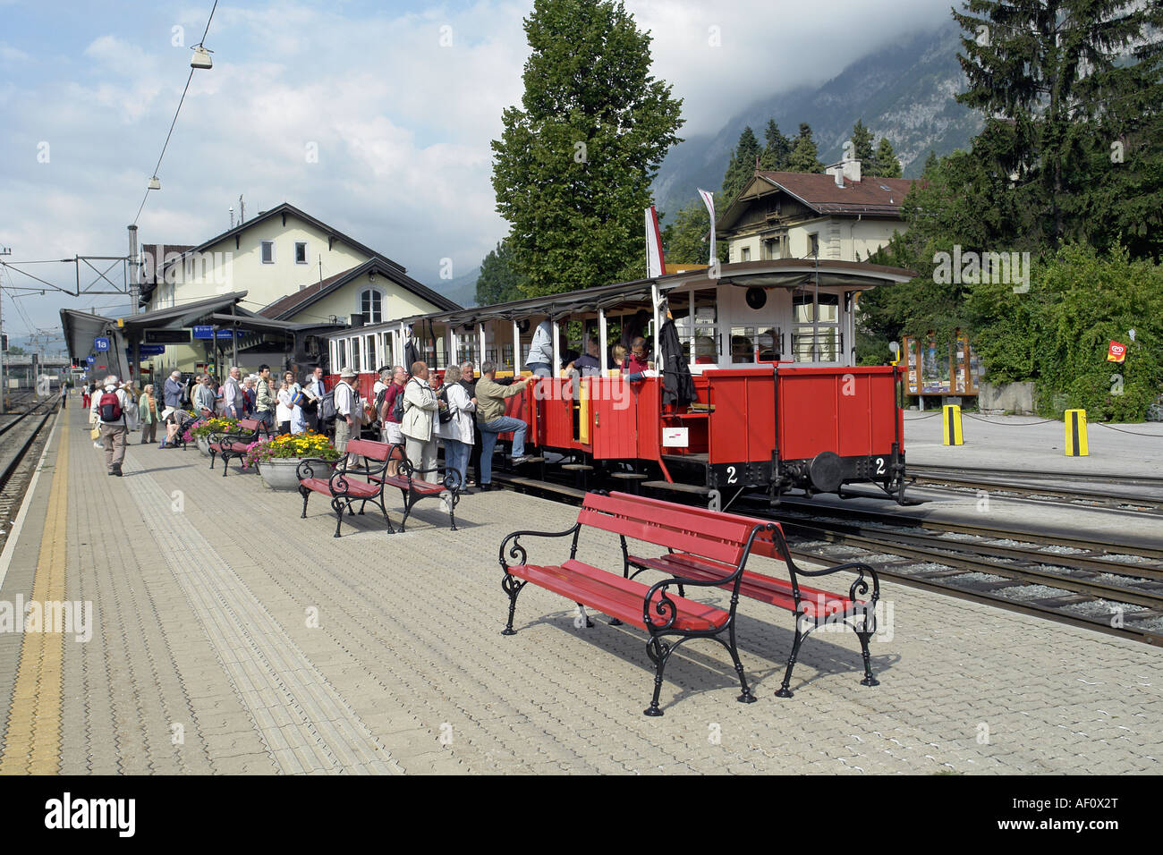 Passengers boarding a morning Achenseebahn steam train at Jenbach in Austria with the main railway station building behind Stock Photo