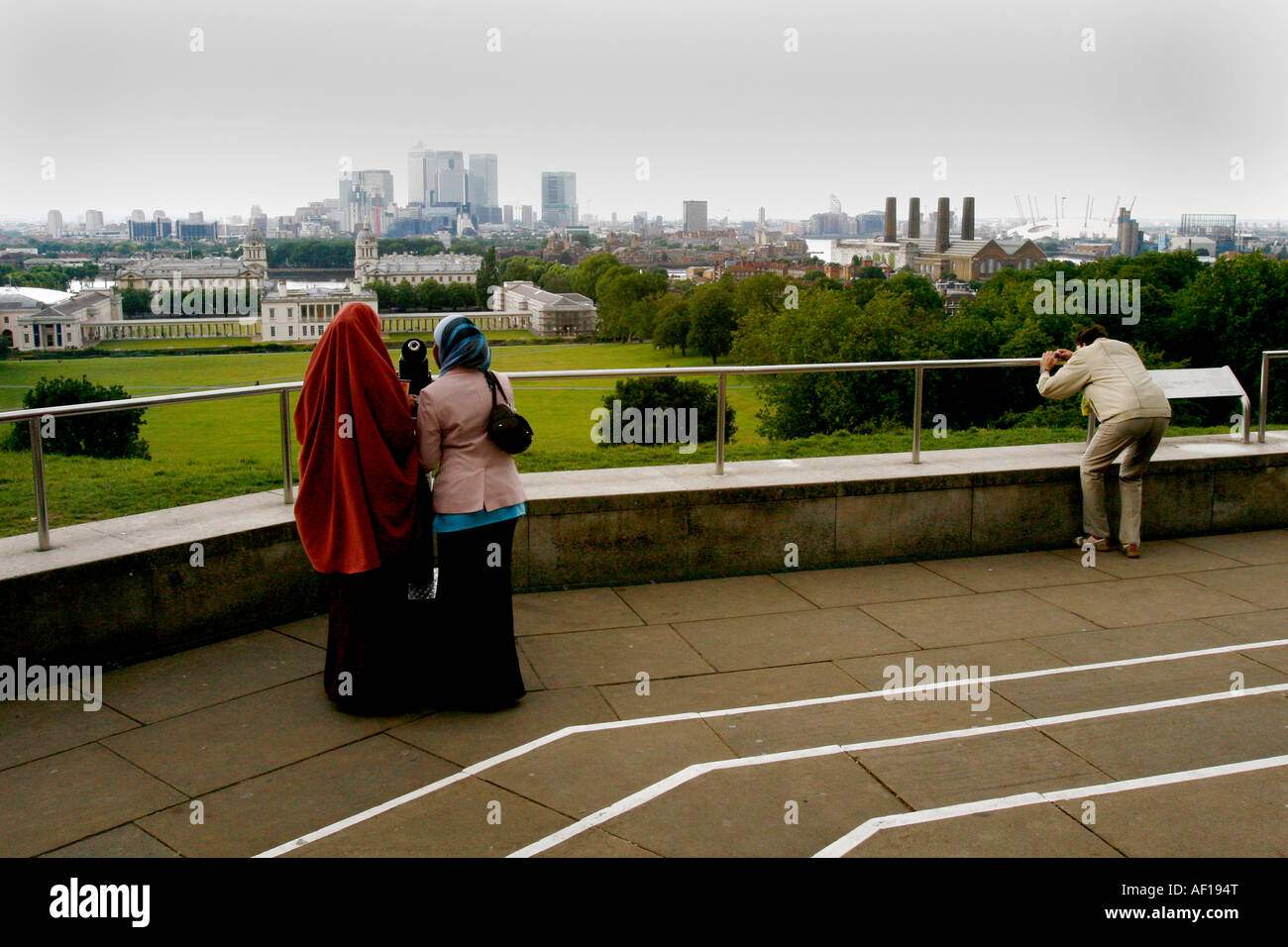 Tourists look out across the World Heritage view from Greenwich Park. Stock Photo