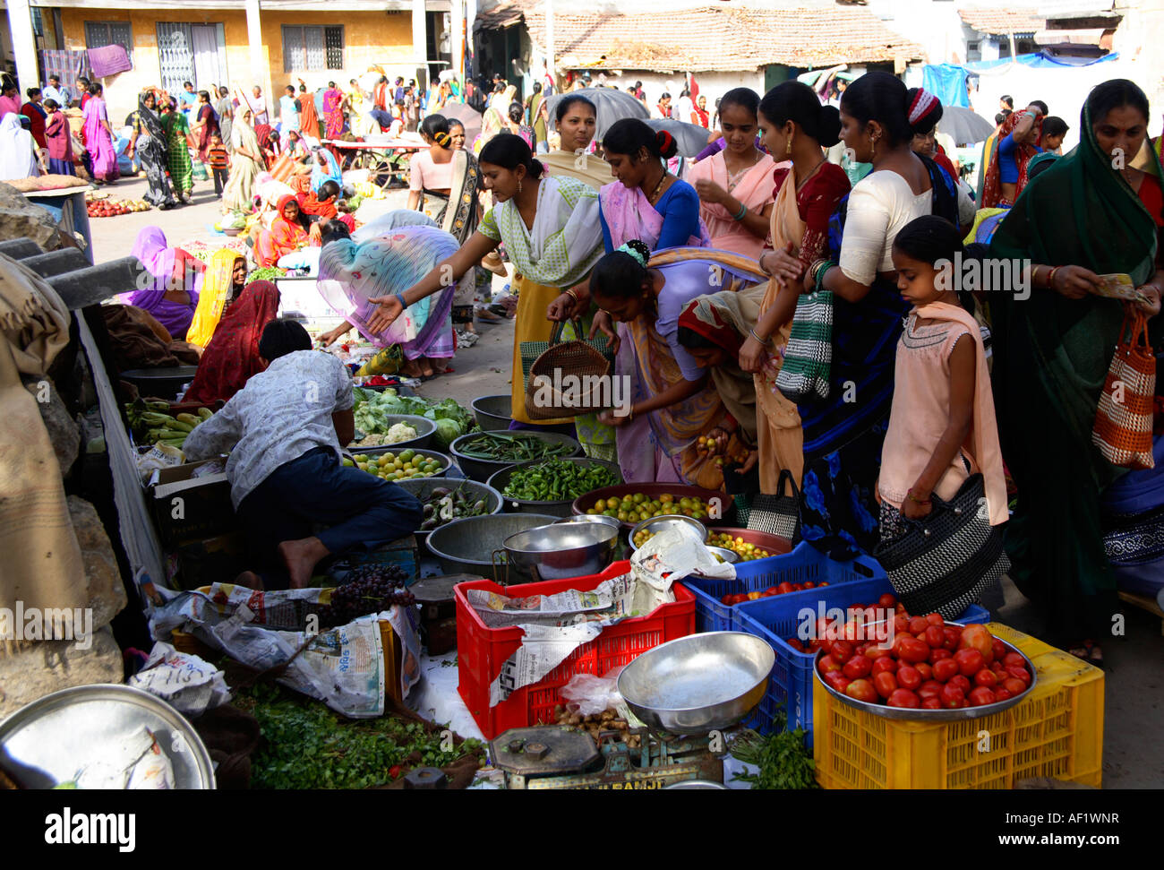 Indian females crowded around busy fruit and vegetable stall in market at Vanakbara Fishing Village, Diu Island, Gujarat, India Stock Photo