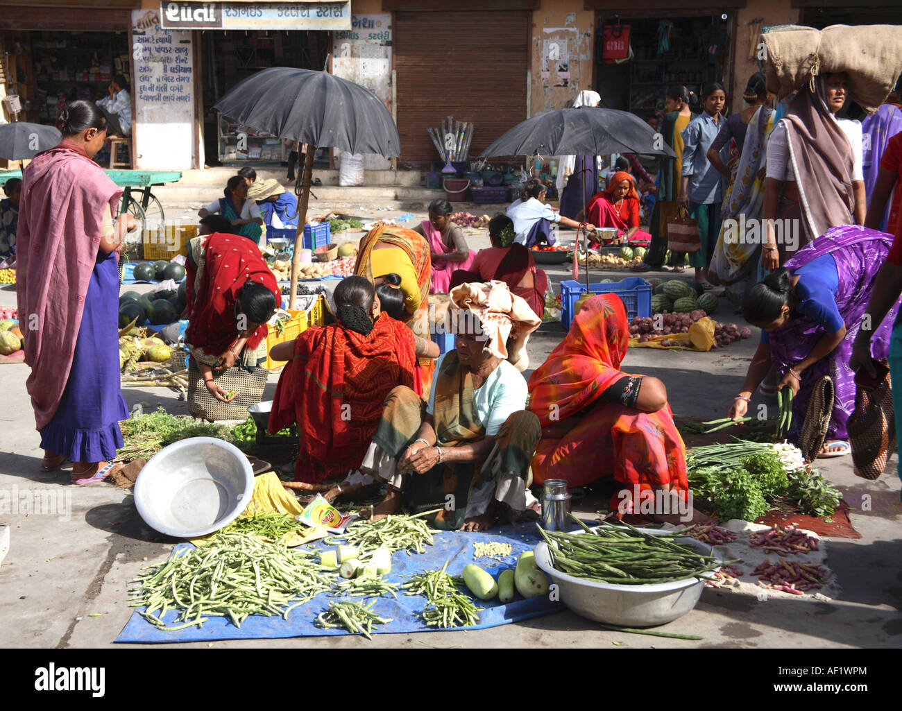 Indian market traders with vegetables laid out on ground in market, Vanakbara Fishing Village, Diu Island, Gujarat, India Stock Photo