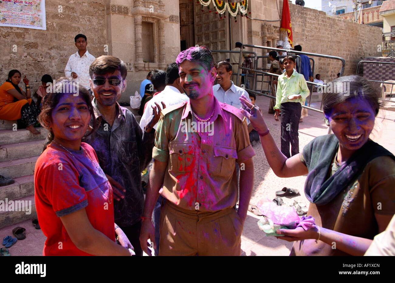 Indian female throwing paint at Temple Official celebrating Holi Spring