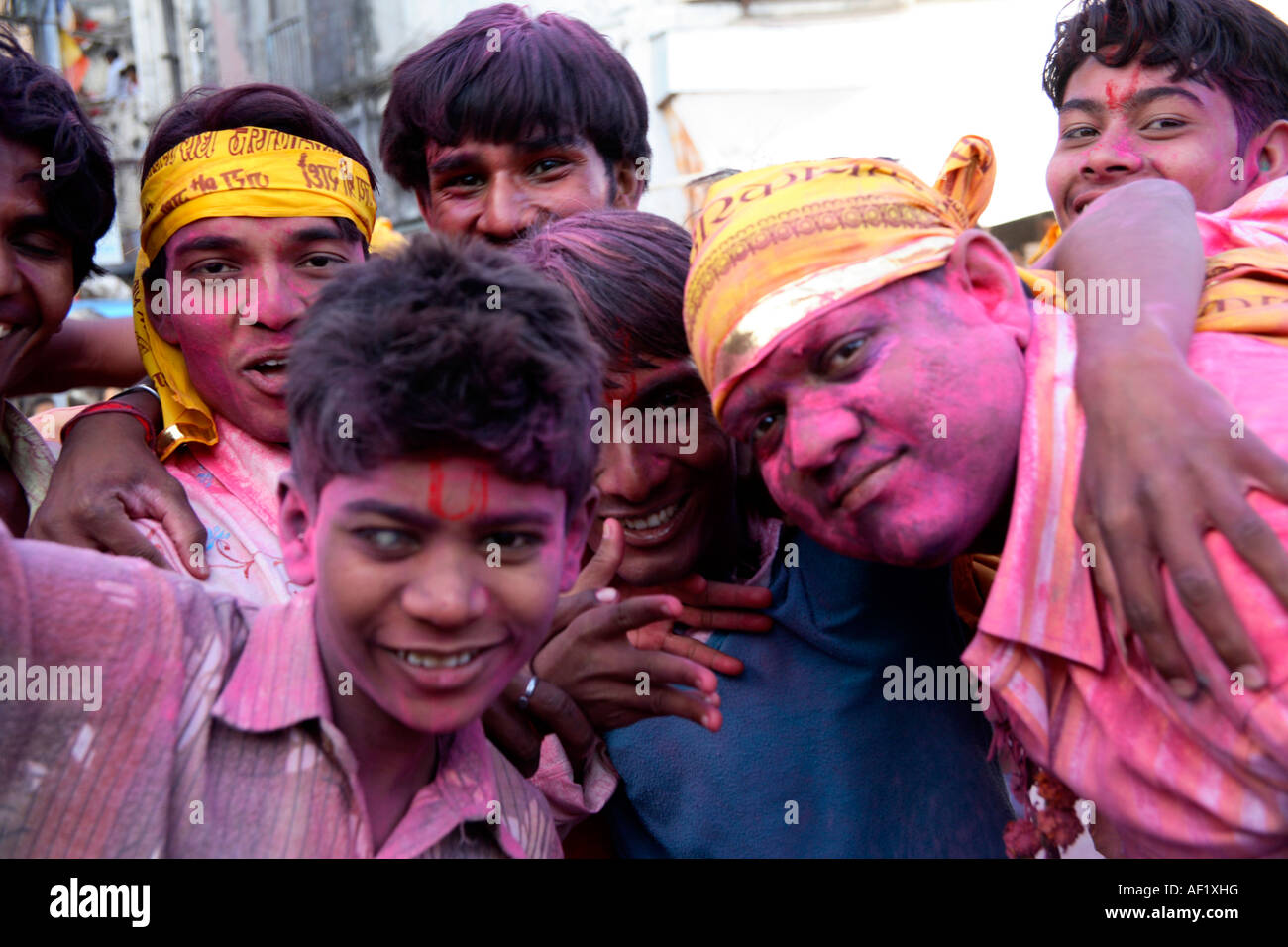Indian males with pink paint splattered on faces and clothes celebrating holi spring festival of colours, Dwarka, Gujarat, India Stock Photo