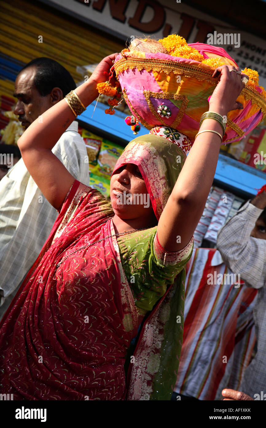 Indian woman with basket of garlands on head celebrating holi spring festival of colours, Dwarka, Gujarat, India Stock Photo