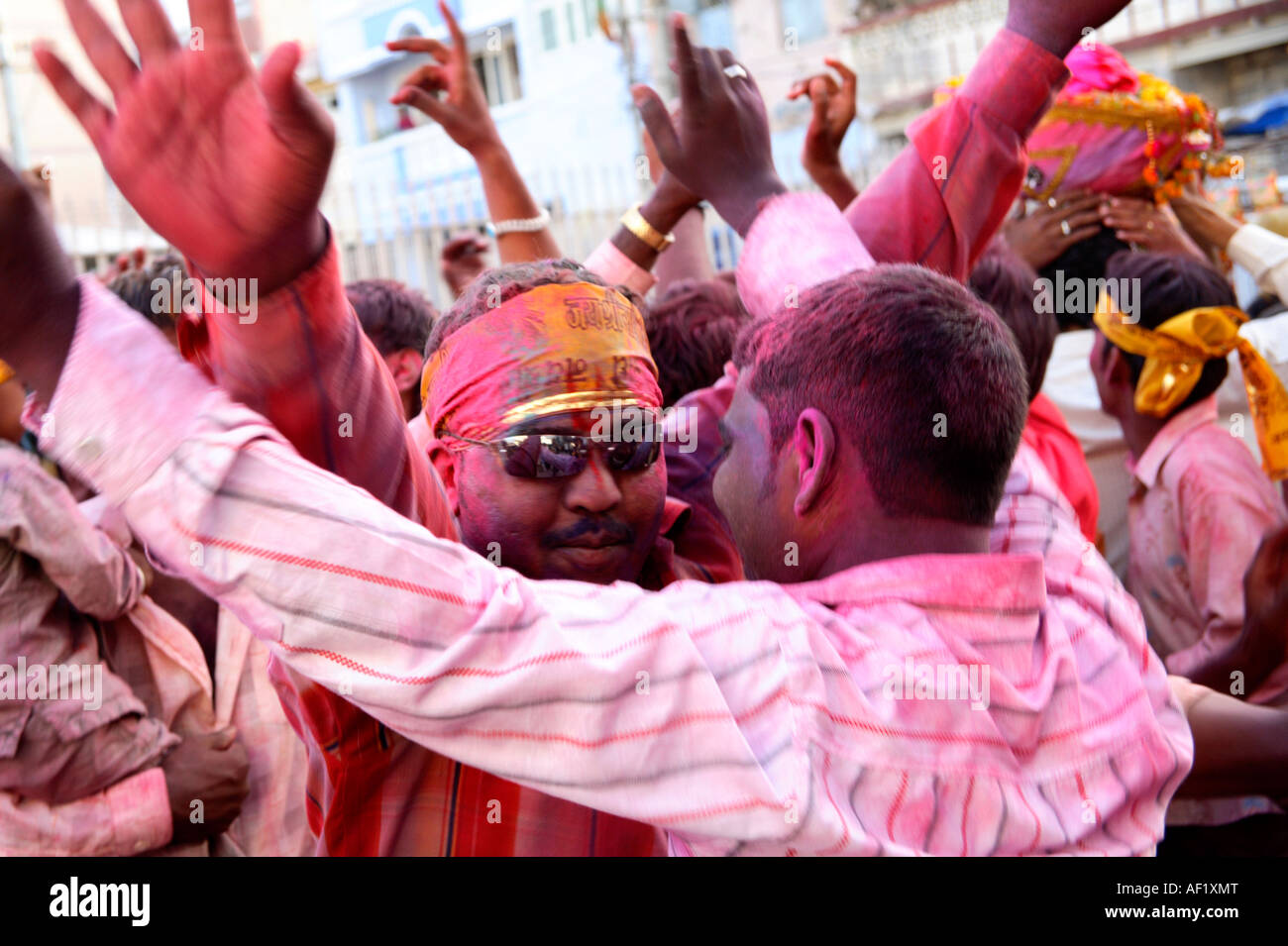 Indian males dancing covered in pink powder celebrating holi spring festival of colours, Dwarka, Gujarat, India Stock Photo