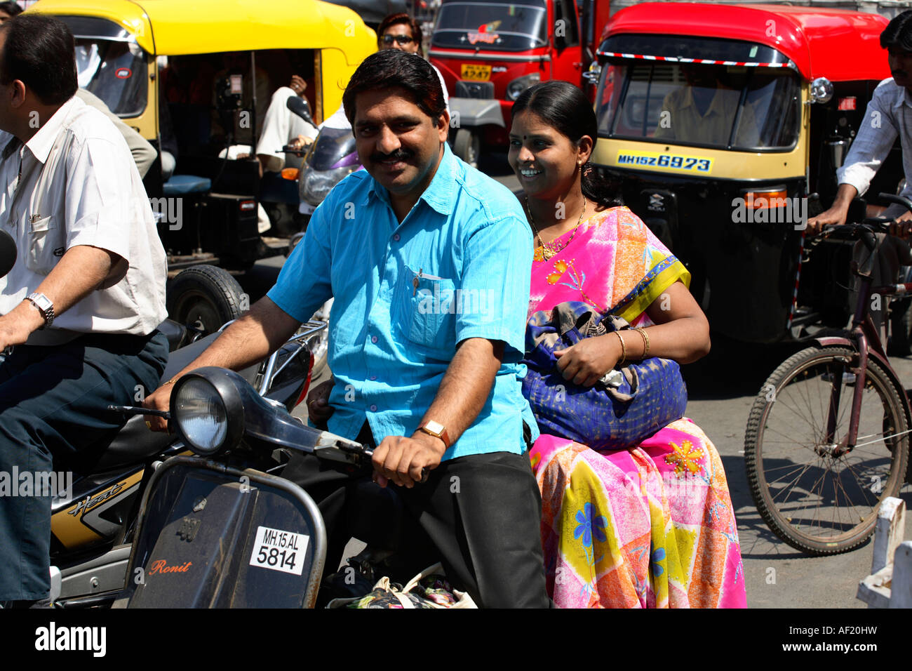 Indian couple riding on scooter without helmets in traffic, Nasik, India Stock Photo