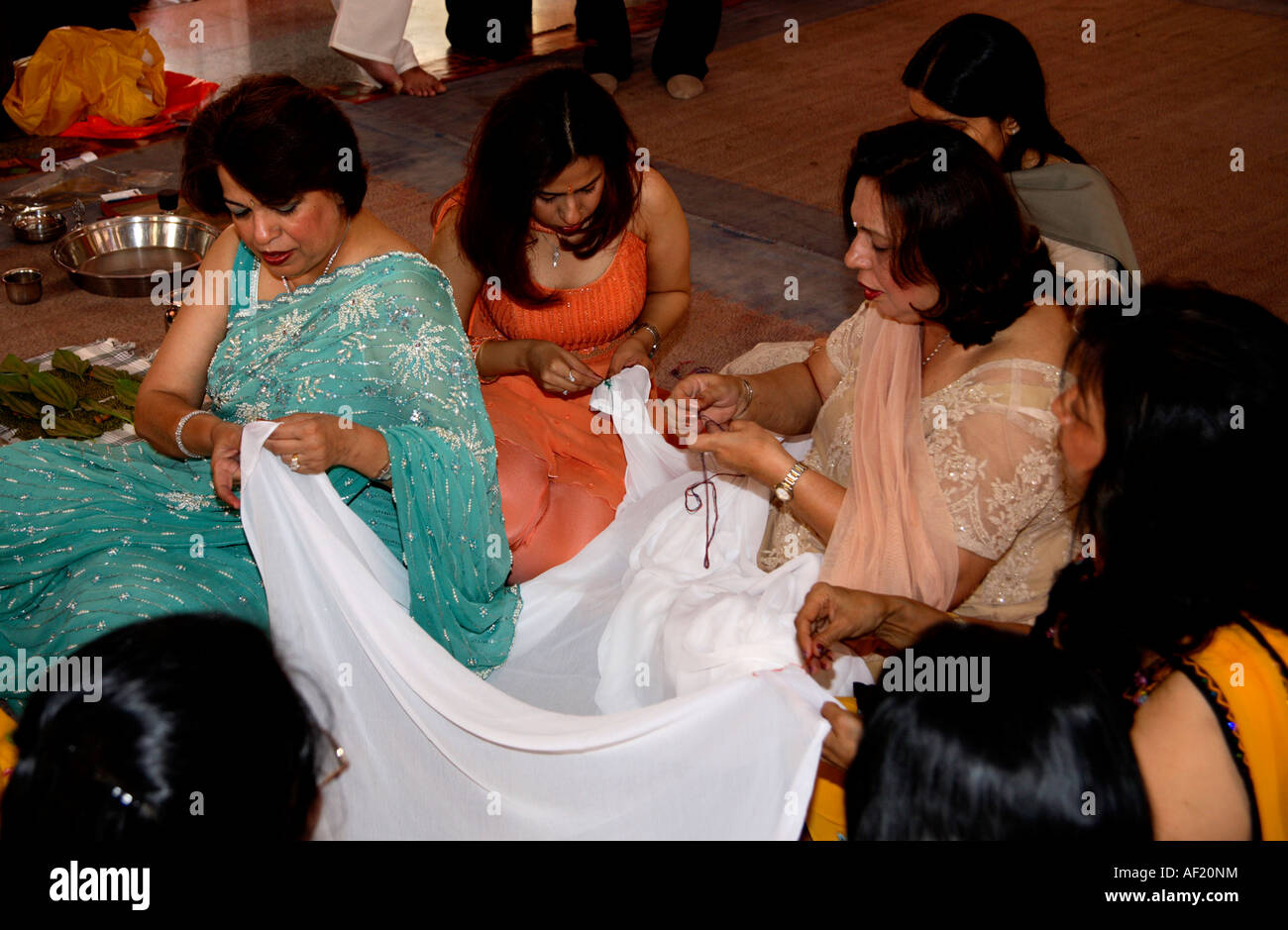 Indian family preparing cloth for the Upanayana (thread ceremony) for their son and brother at