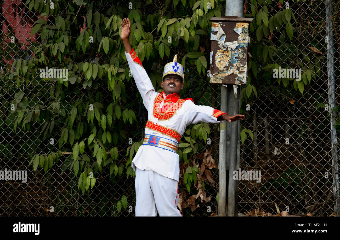 Indian musician in garish band uniform clowning around walking through streets in Pune, India Stock Photo