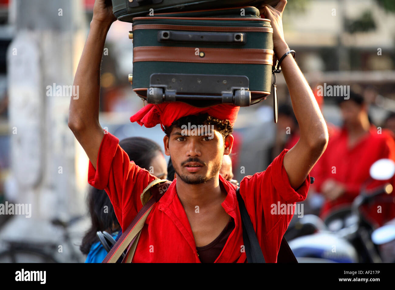 Porter carrying luggage at railway station, Pune, India Stock Photo