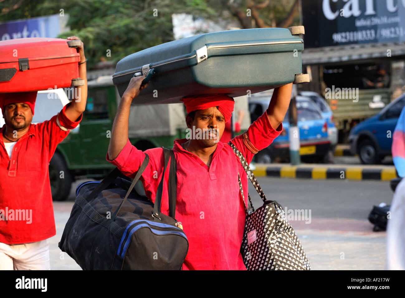 Indian Porters carrying suitcases on heads at railway station, Pune