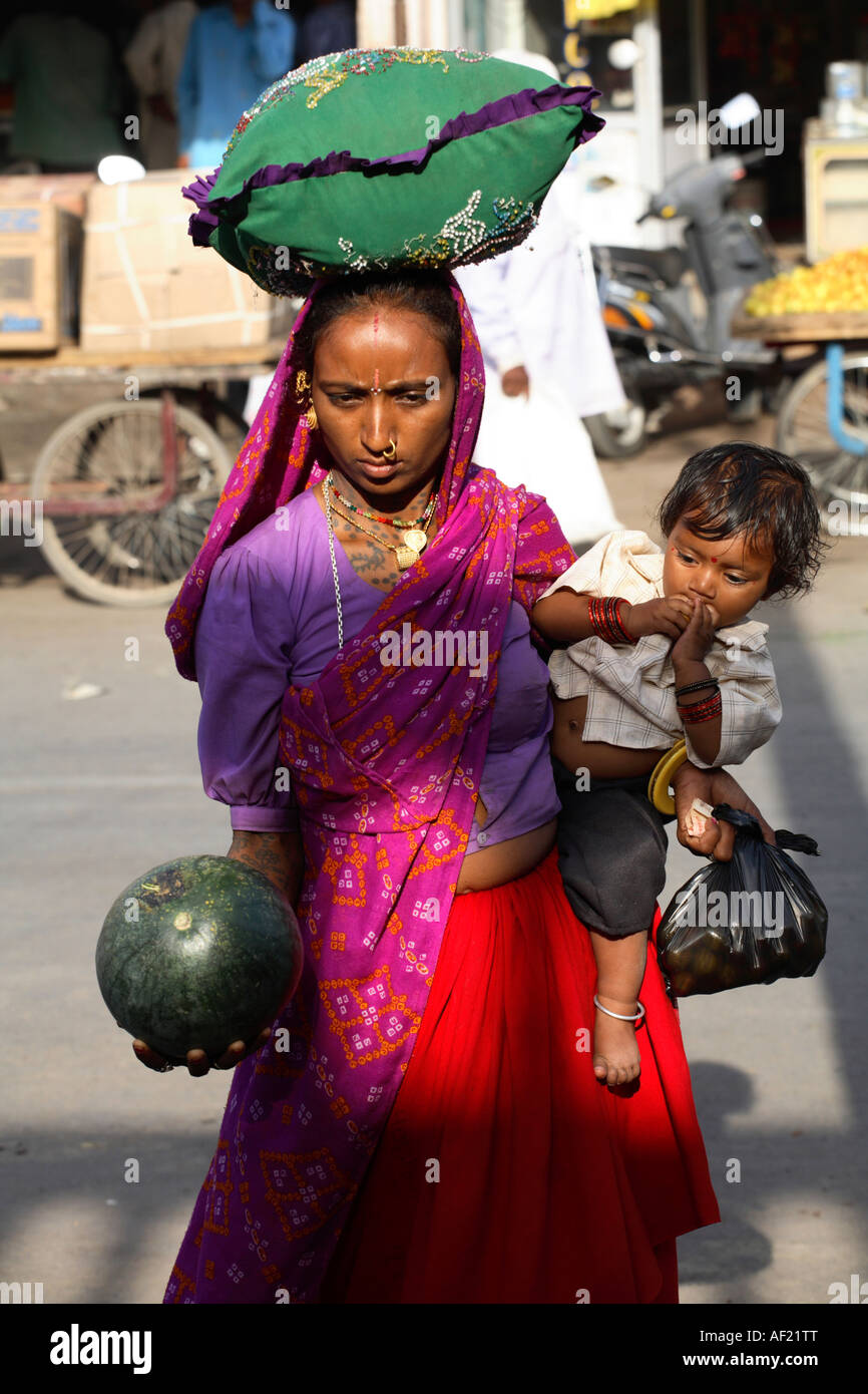 Rabari tribal woman with child selecting melon at market stall, Una, Gujarat, India Stock Photo