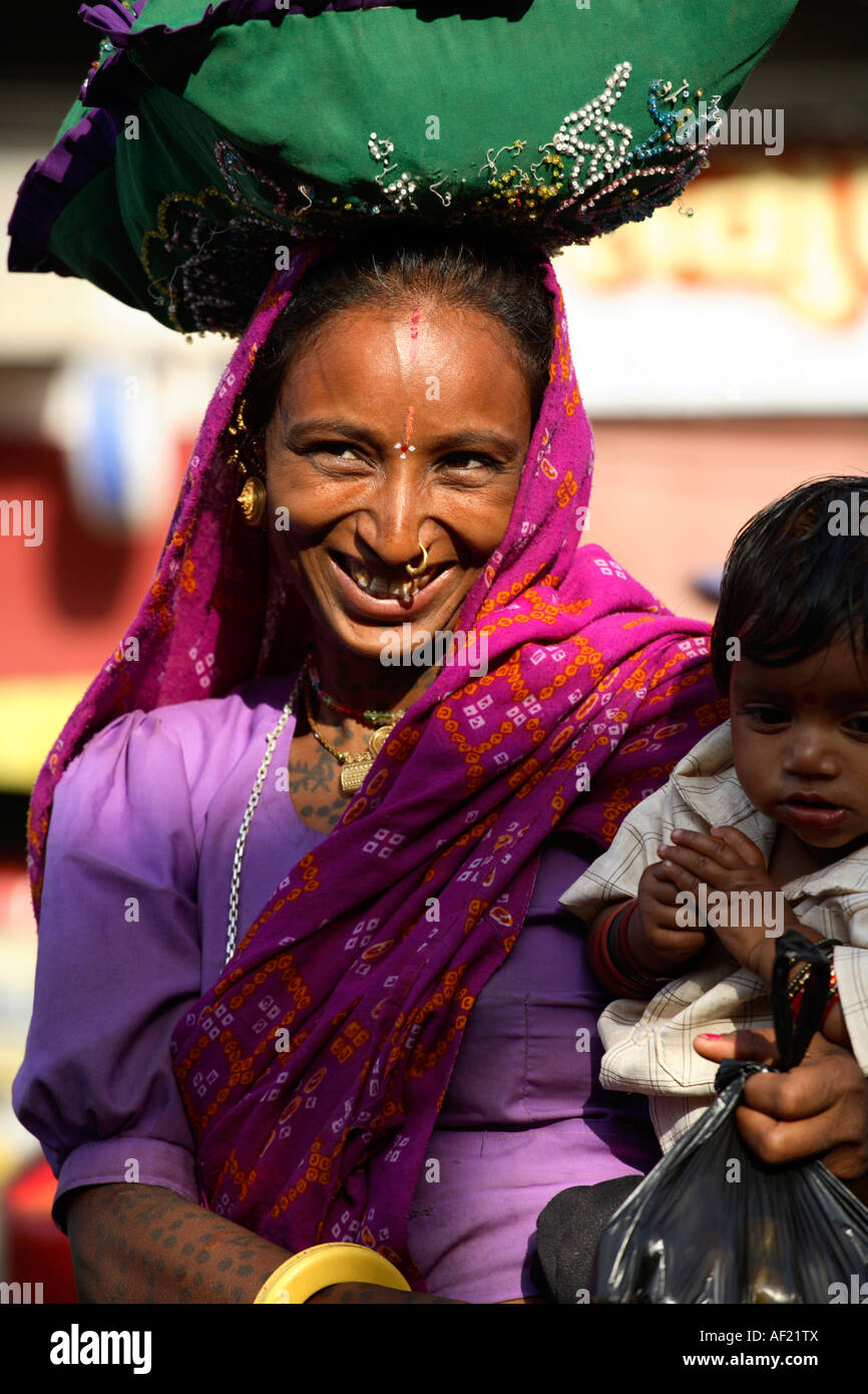 Rabari tribal woman with neck and arm tattoos selecting fruit at market stall, Una, Gujarat, India Stock Photo