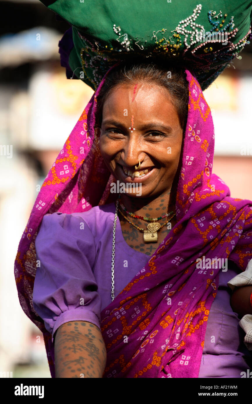 Attractive Rabari tribal woman with neck and arm tattoos selecting fruit at market stall, Una, Gujarat, India Stock Photo