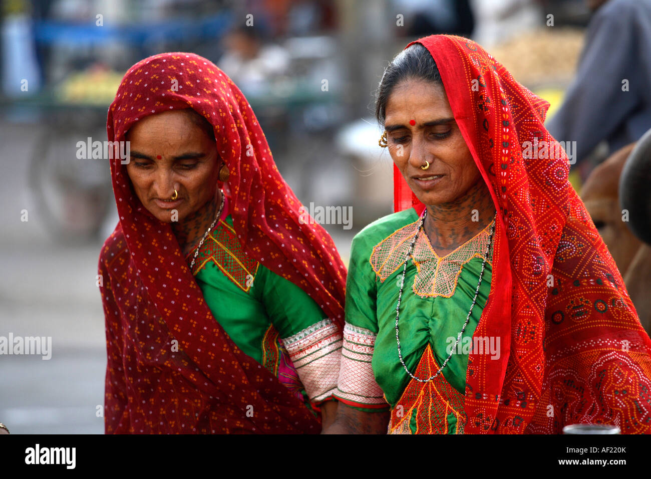 Rabari Tribal women with neck tattoos choosing market produce, Una, Gujarat, India Stock Photo