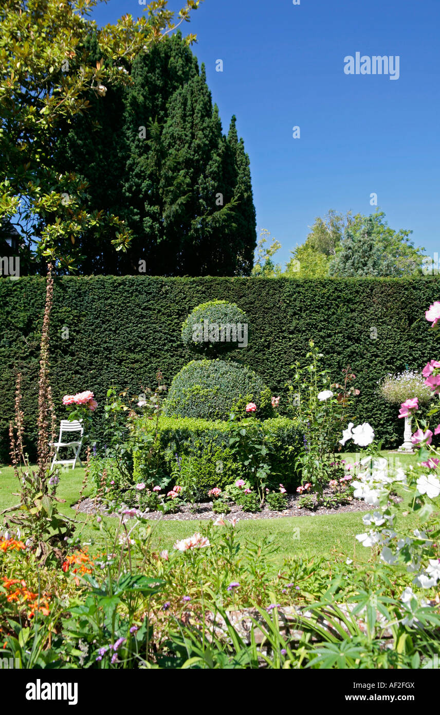 Picturesque traditional English cottage garden featuring Topiary at St