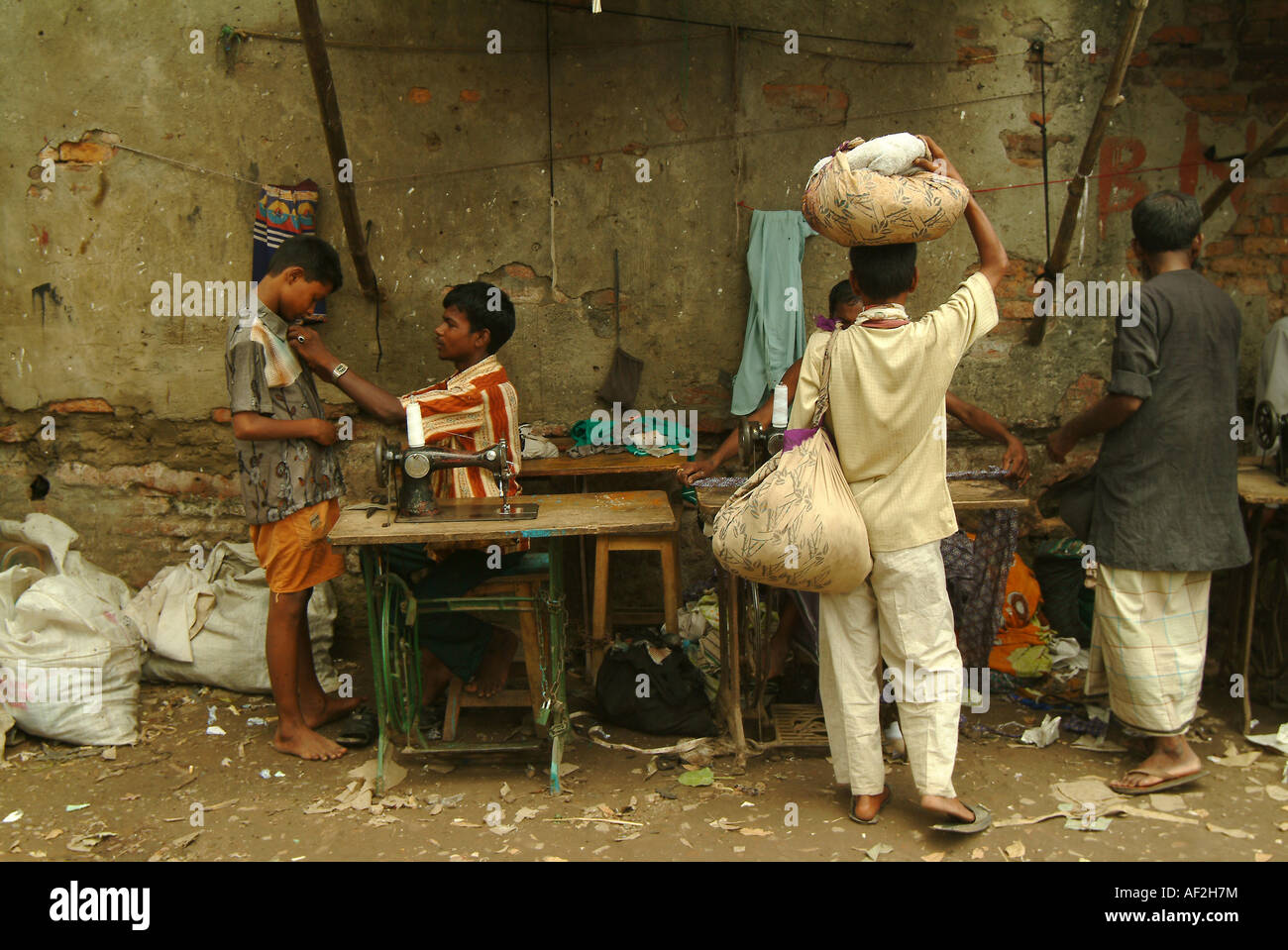 Tailors work under canopies on the side of the street in old Dhaka ...
