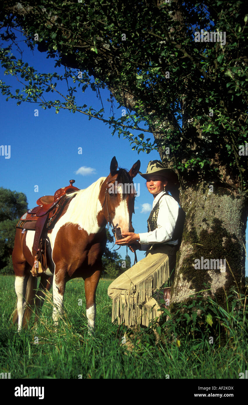 a young western style riding woman with her Paint Horse Stock Photo - Alamy