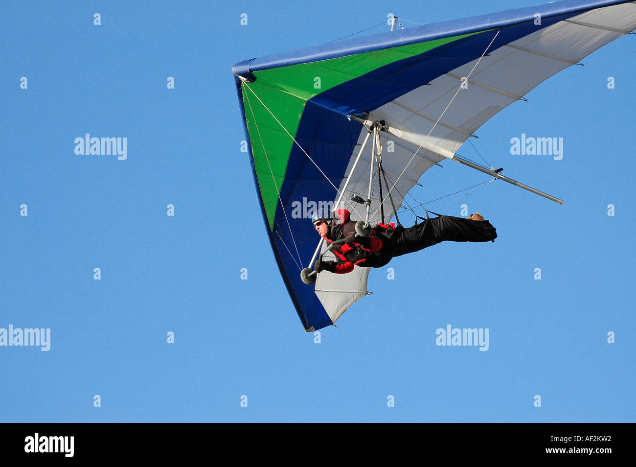Hang glider flying into the sun so you can see his face and under 