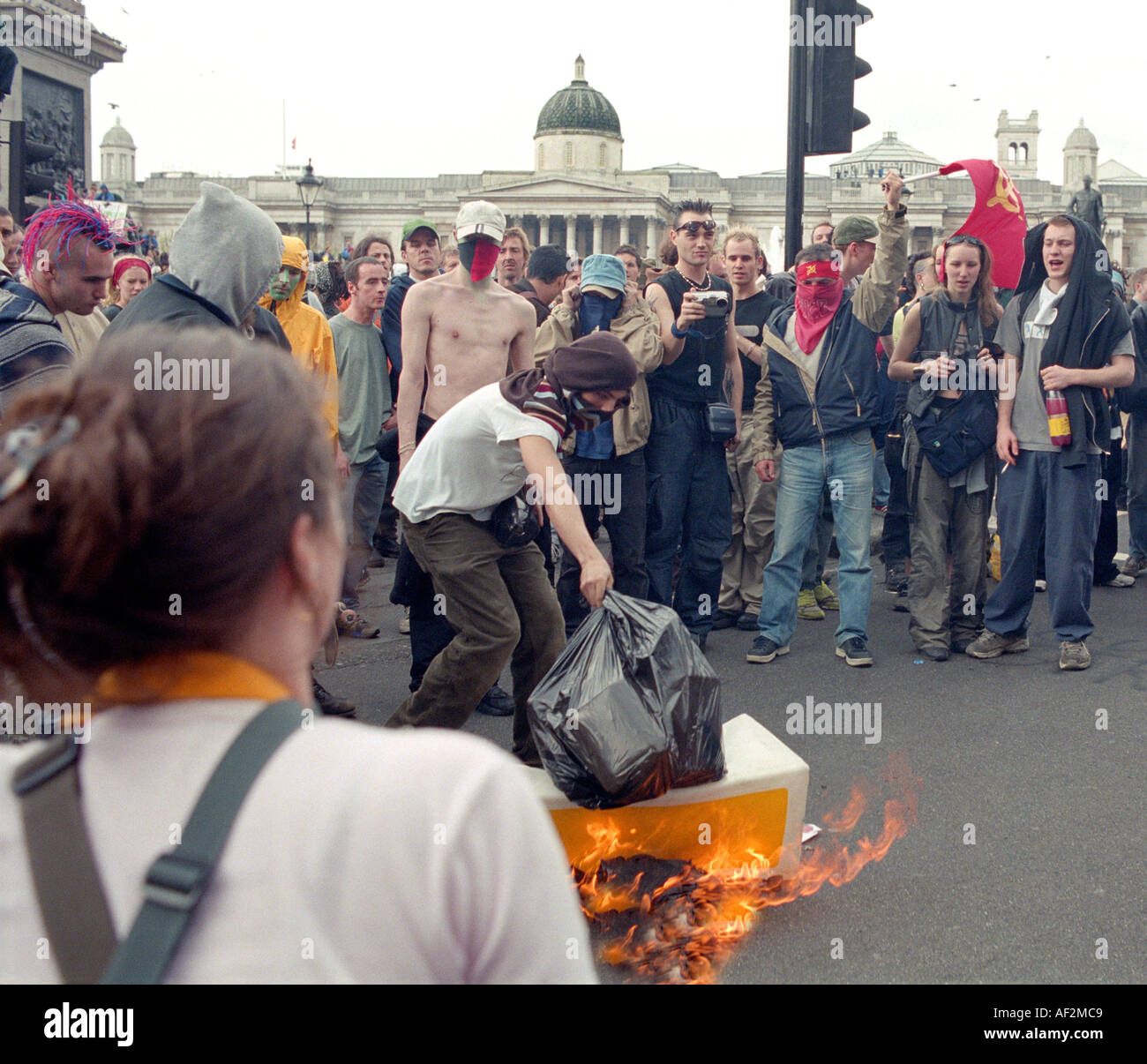 Protesters setting light to traffic islands and rubbish during riots of Mayday 2000 in Trafalgar Square London. Stock Photo