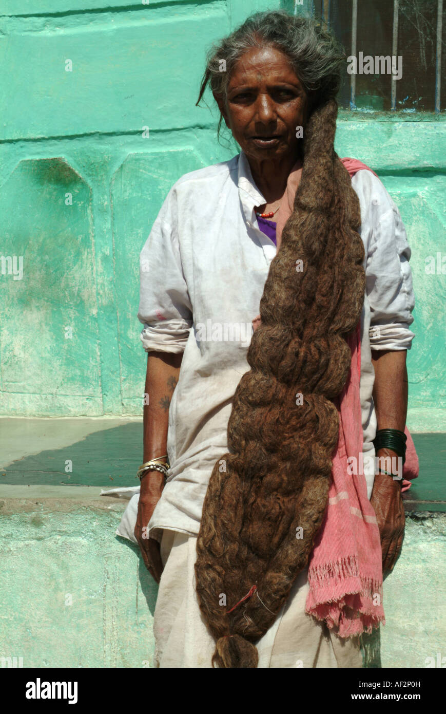 An old Indian woman with one large dread lock poses in Hampi, Karnataka, Southern India. Stock Photo