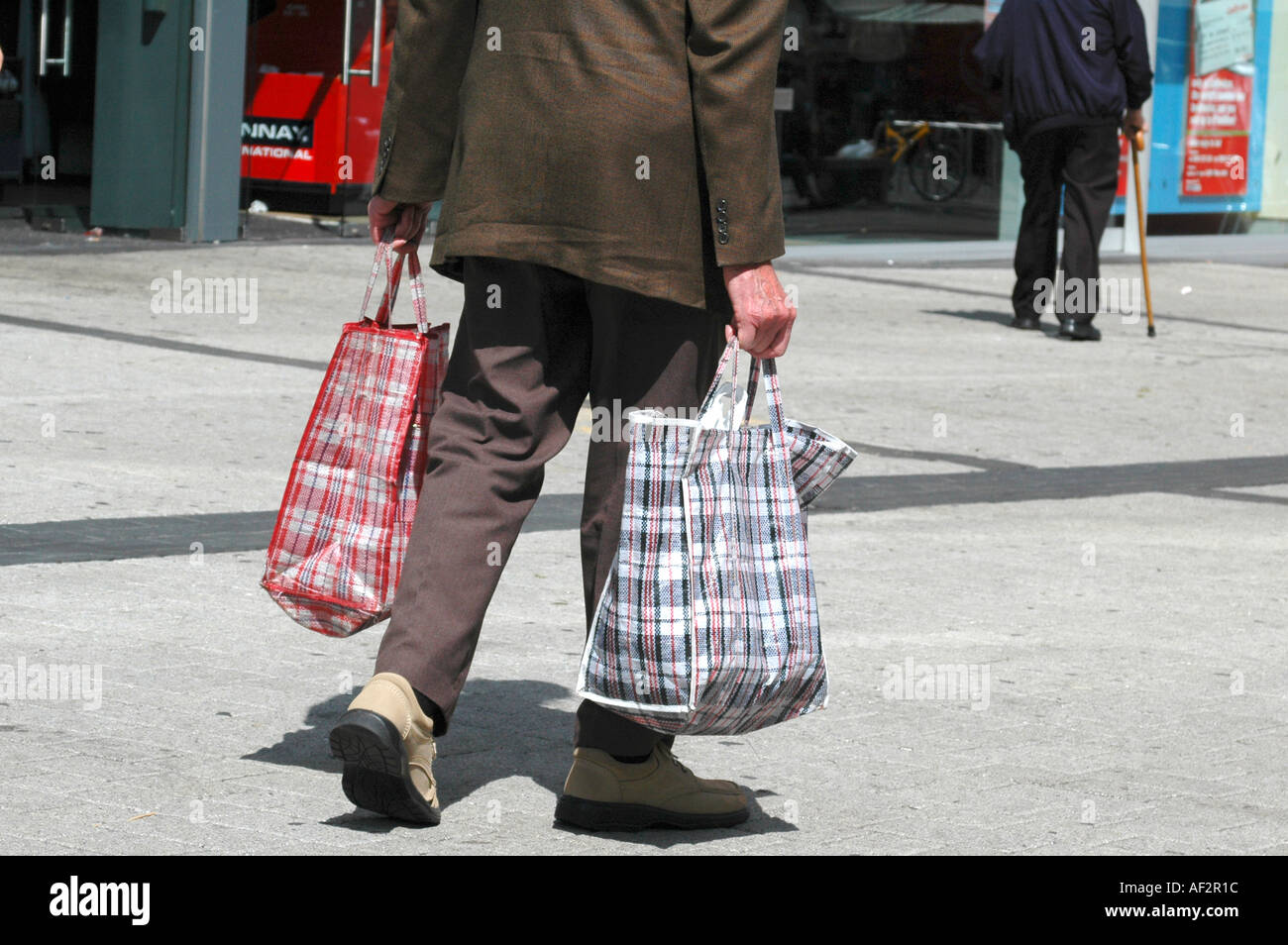 Elderly male shopper carrying shopping bags Bullring Centre Birmingham
