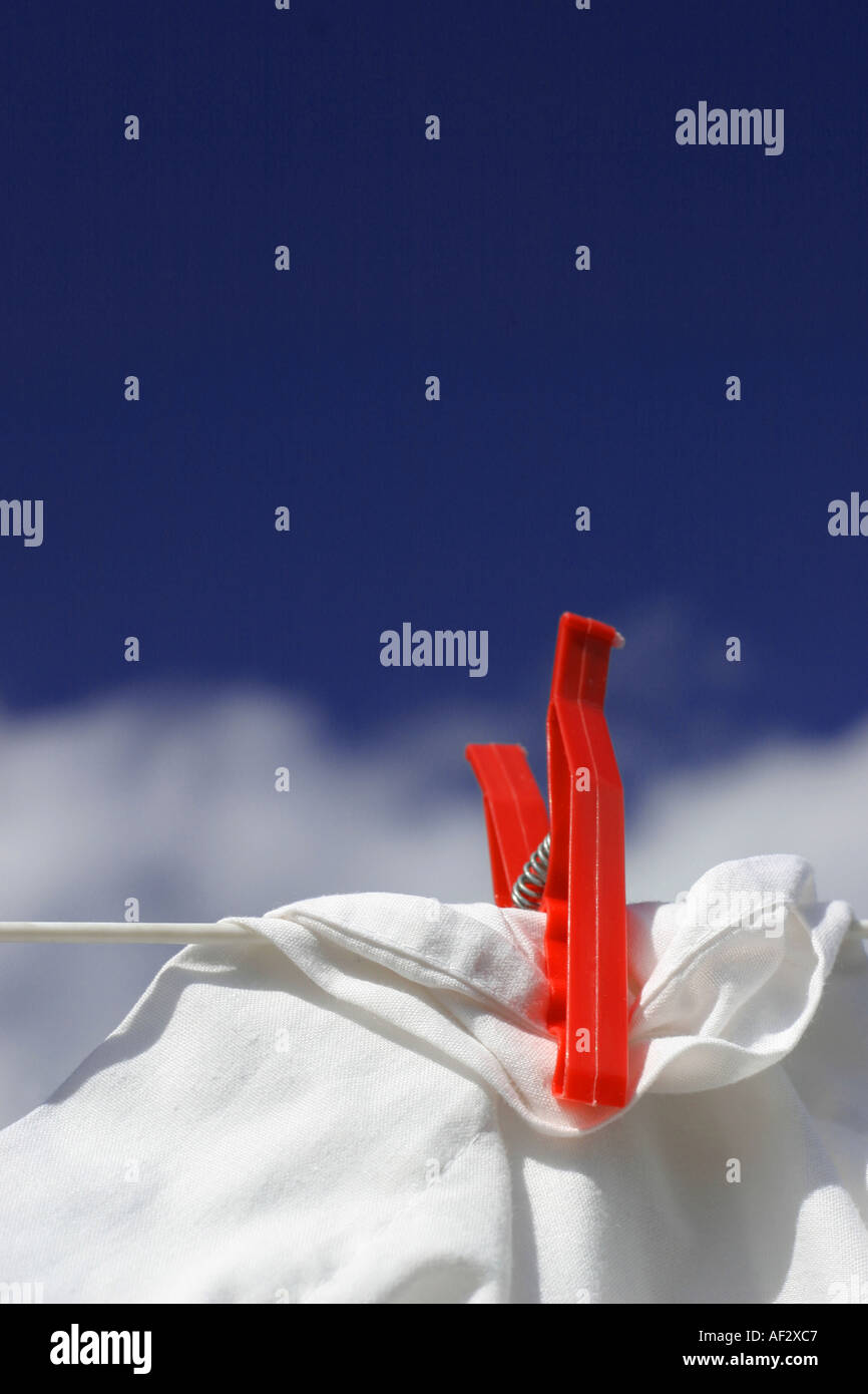 red clothes peg on white sheet with washing line Stock Photo