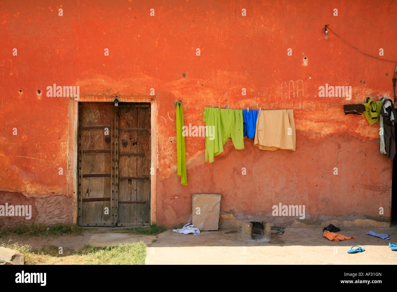 Amazing earth colours of wall, traditional wooden door and drying laundry in historical Indian Jaigarh Fort, near Amer in Jaipur, Rajasthan, India Stock Photo