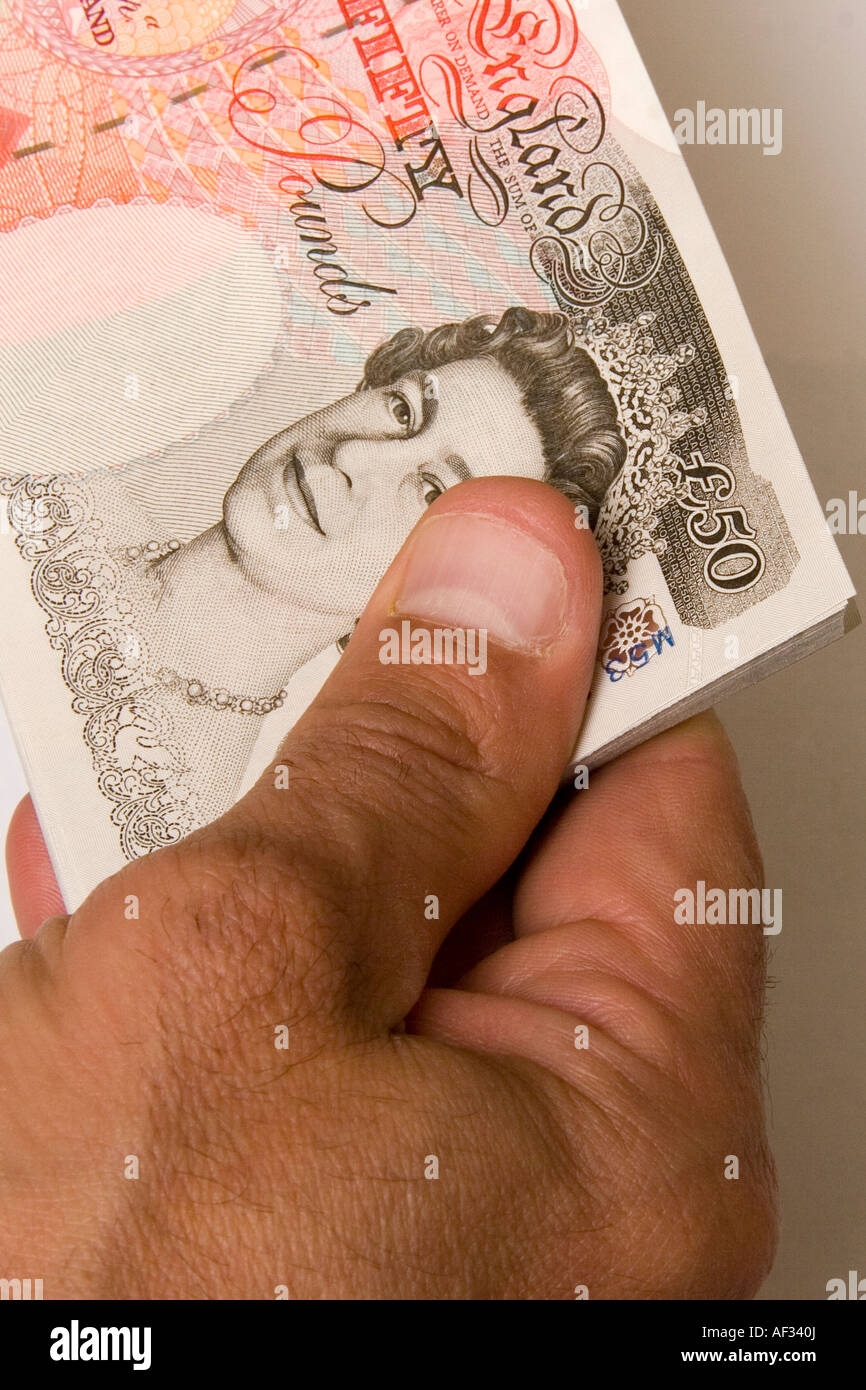 A man holding five thousand in cash in new fifty pound notes in his hand 5000 50 Stock Photo